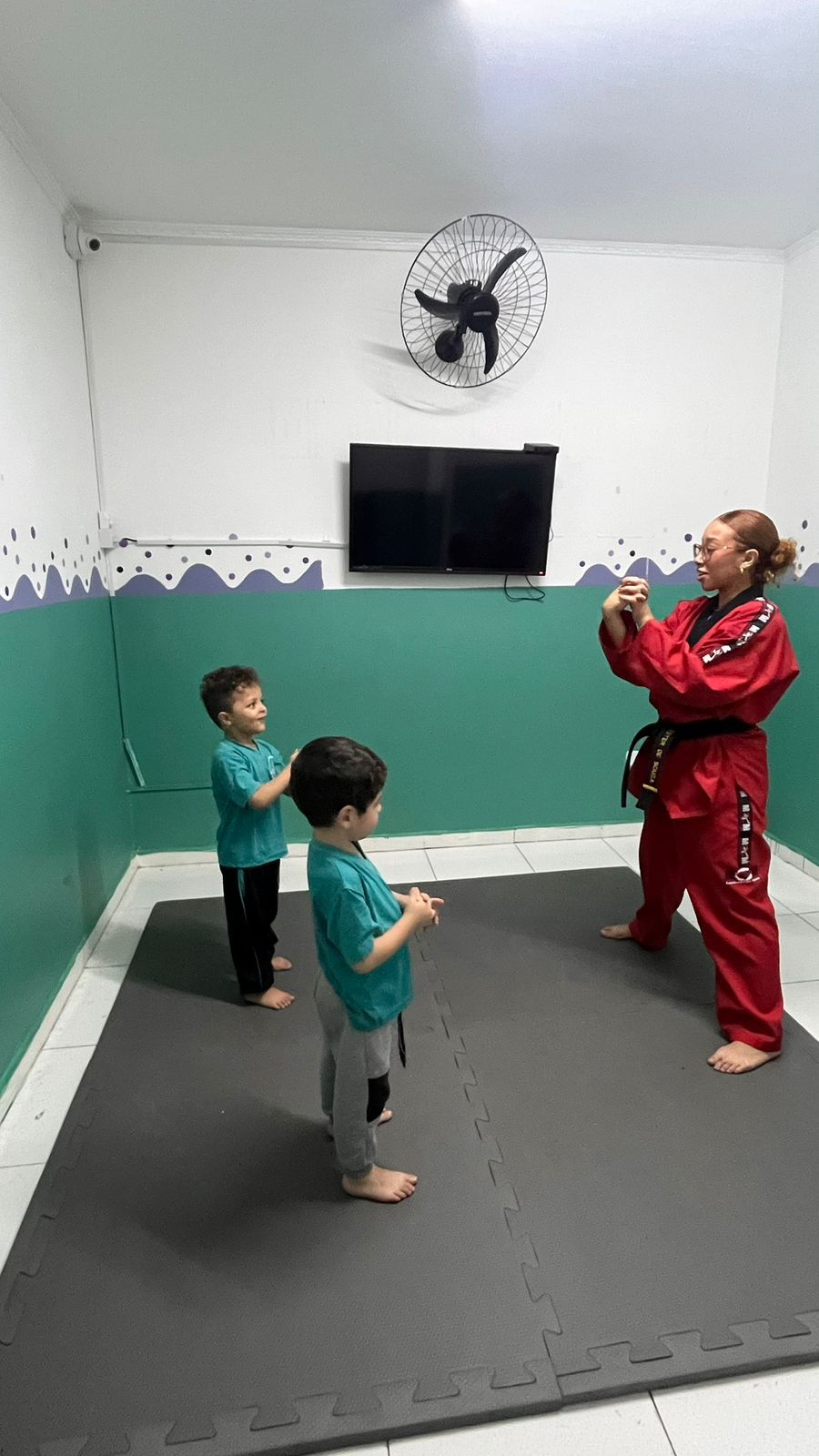 Crianças participando de aula de taekwondo